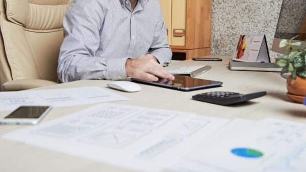 Young bearded businessman using application on tablet computer